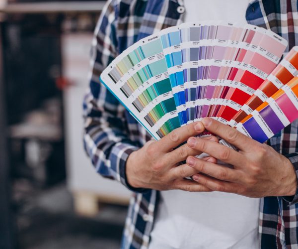 Man working in printing house with paper and paints